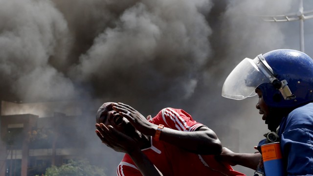 A detained protester cries in front of a burning barricade during a protest against President Pierre Nkurunziza's decision to run for a third term in Bujumbura