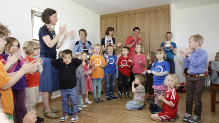 Geretsried: Leiterin Chiara Belli-Obser (links) und die Kinder, auf deren T-Shirts das neue Temenos-Symbol zu sehen ist.