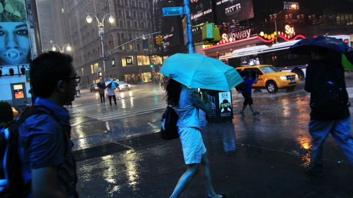 People walk through heavy rain at Times Square in New York