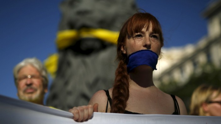 Woman with a mask attends a gathering to mark the fourth anniversary of the 15M movement at Madrid's landmark Puerta del Sol Square