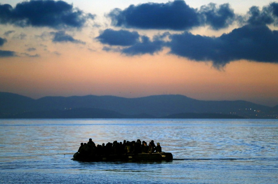 A dinghy overcrowded with immigrants is towed by a Greek coast guard patrol boat into the port on Kos