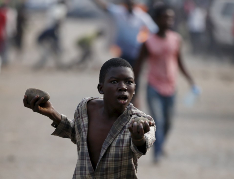 A boy gestures as he holds stones during a protest against Burundi President Pierre Nkurunziza and his bid for a third term in Bujumbura