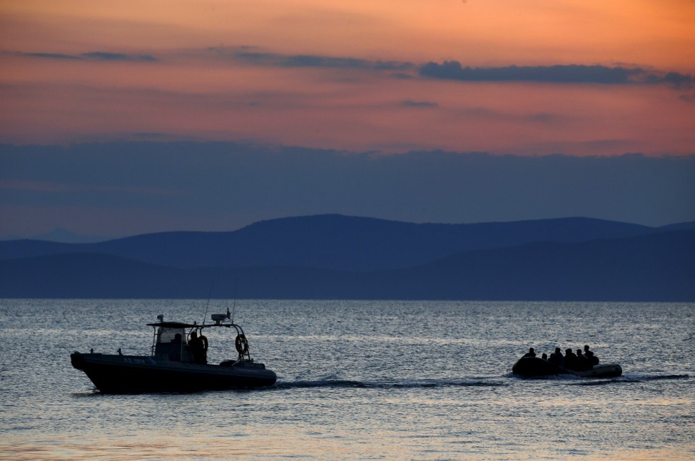 A dinghy with Syrian refugees is towed into the port of Kos