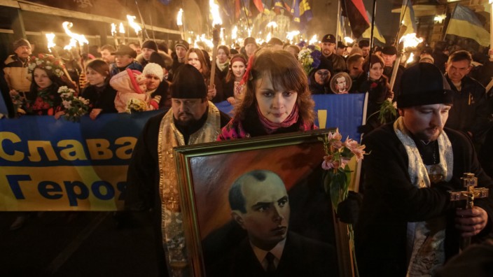 Activists of the Svoboda (Freedom) Ukrainian nationalist party hold torches as they take part in a rally to mark the 105th year since the birth of Stepan Bandera in Kiev