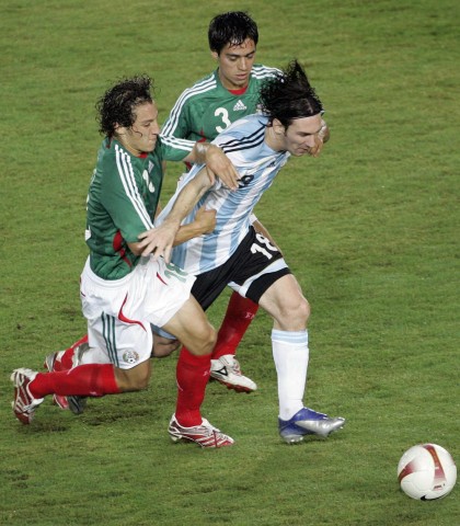 Argentina's Messi tries to break through Mexico's Pinto and Guardado in the semi-finals of the Copa America soccer tournament in Puerto Ordaz