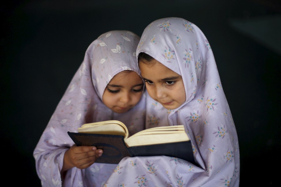 Palestinian girls read the Koran as they attend a Koran memorisation lesson during summer vacation inside a mosque in Gaza City