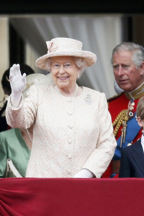 Britain's Queen Elizabeth waves as Prince Charles stands behind on the balcony at Buckingham Palace after attending the Trooping the Colour ceremony at Horse Guards Parade in central London