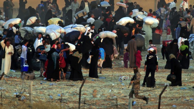 Flucht vor dem IS: Syrische Frauen, Männer und Kinder, bepackt mit ihren Habseligkeiten.