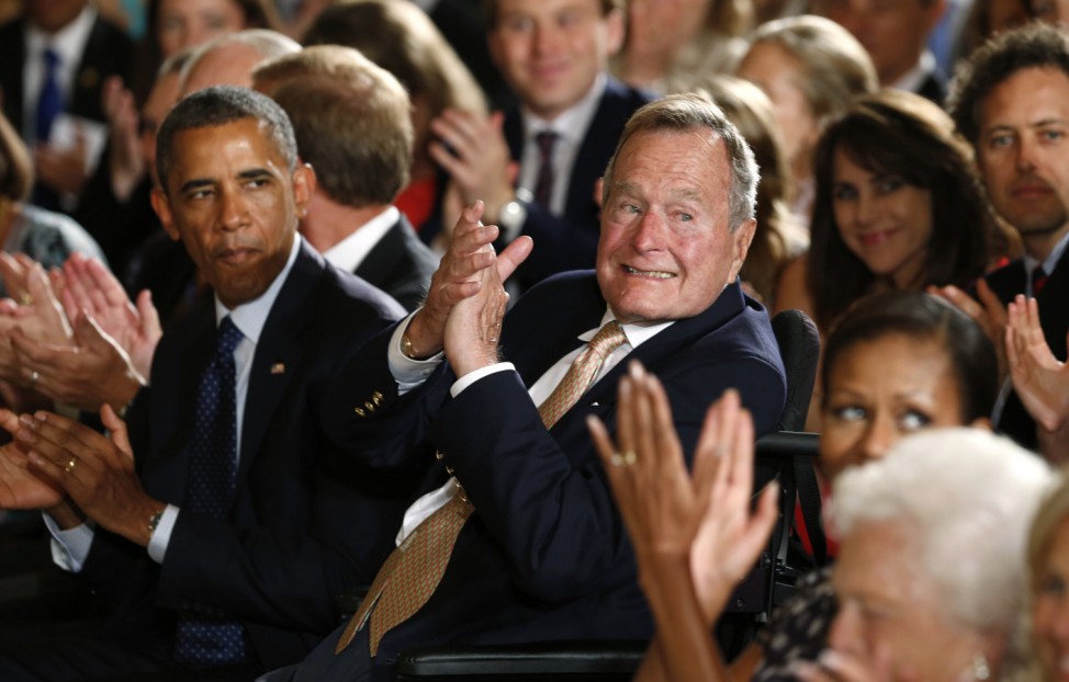 U.S. President Barack Obama and former President George H. W. Bush applaud during an event to honor the winner of the 5,000th Daily Point of Light Award at the White House in Washington