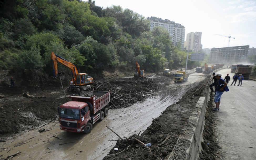 Workers clean debris on the street near the zoo in Tbilisi