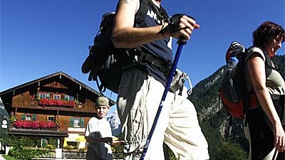 Straße für das Kaisertal: Wanderer gehen auf einem Weg in der Nähe des Berggasthofes Pfandlhof im Kaisertal bei Kufstein in Tirol.