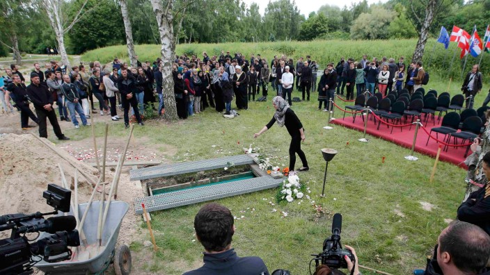 A woman pays her respects during a muslim funeral a female refugee at Gatow cemetery in Berlin