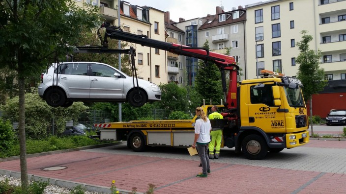 Entführung in München: Auf dem Parkplatz, der aus den angrenzenden Häusern gut einsehbar ist, endete die Entführung. Zur Spurensicherung wurde der Pkw des Opfers abtransportiert