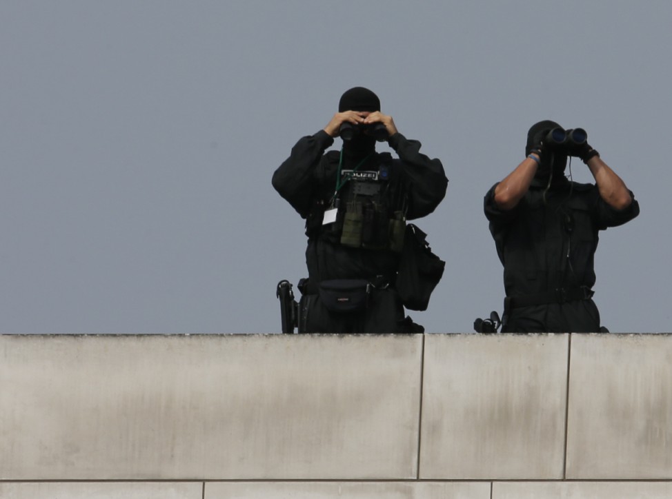German special police officers watch from the roof of a building at Pariser Platz during the visit of Queen Elizabeth and Prince Philip to Berlin