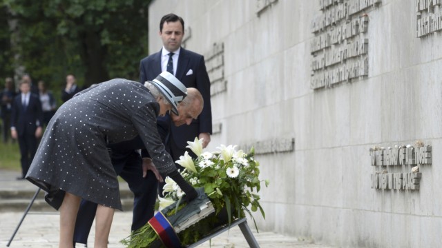 Britain's Queen Elizabeth and Prince Philip lay a wreath in front of the inscription wall during a visit to the site of the former Nazi concentration camp Bergen-Belsen