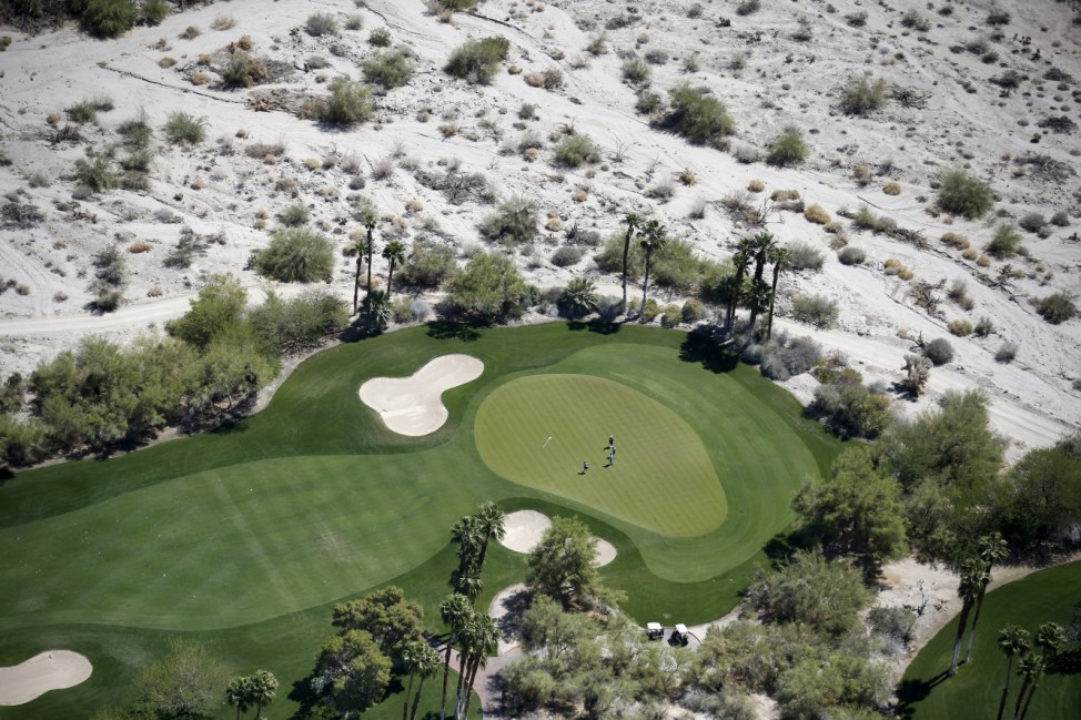 People play golf on a course in La Quinta
