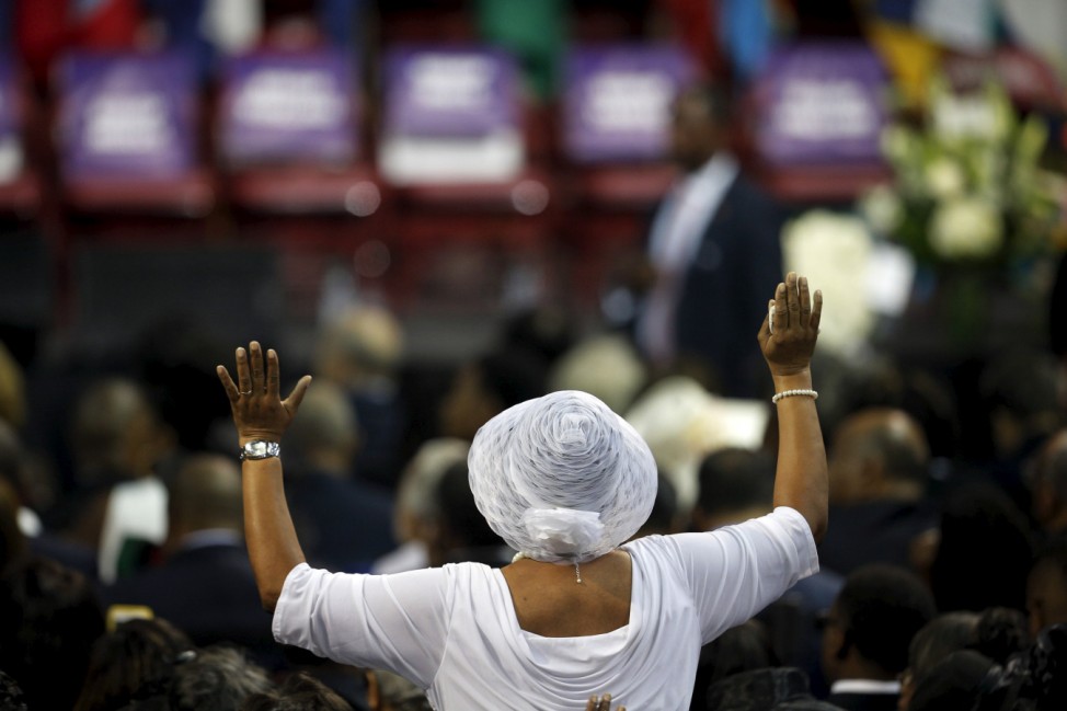 A mourner raises her hands as the choir sings ahead of funeral services for the Reverend Clementa Pinckney in Charleston