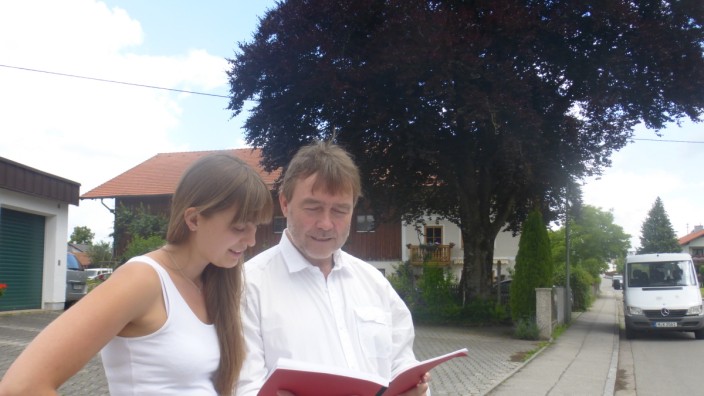 Egmating: Bernhard Wagner und Tochter Magdalena betrachten gemeinsam die Diplomarbeit, die der Gemeinderat über die Münchner Baumschutzverordnung verfasst hat.