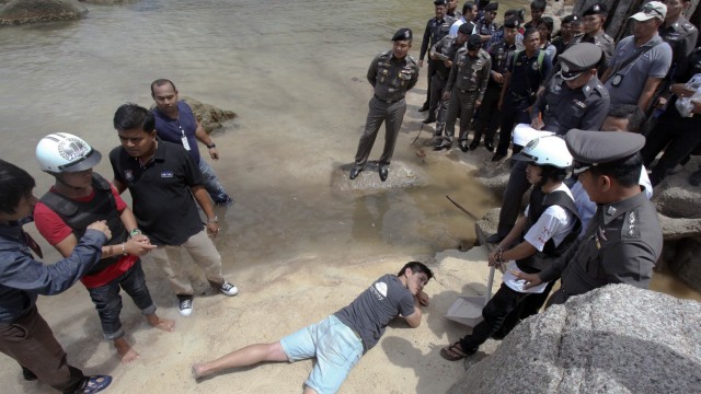 Two workers from Myanmar, suspected of killing two British tourists on the island of Koh Tao last month, stand during a re-enactment of the alleged crime, on the island