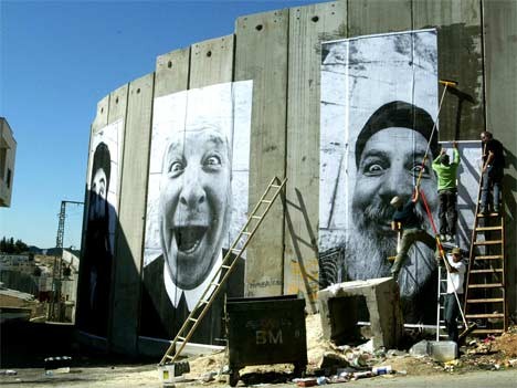 Französische Künstler kleben bilder von lachenden Israelis und Palästinensern an die Mauer in Bethlehem. Foto: AFP