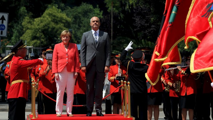 German Chancellor Angela Merkel and Albania's Prime Minister Edi Rama listen to their national anthems during a welcoming ceremony in Tirana