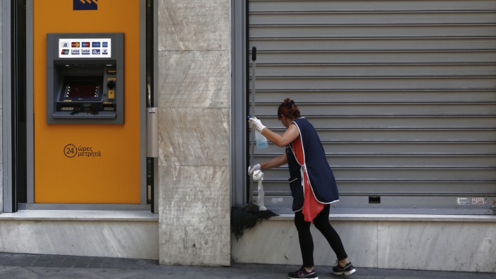 Finanzkrise in Griechenland: Eine Frau putzt vor einer geschlossenen Bankfiliale in Athen.