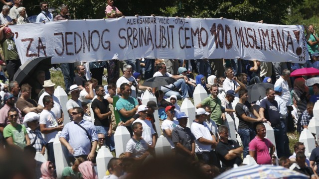 A banner reading 'For one Serbian we are going to kill 100 muslims!', a quote attributed to Serbian PM Vucic, is seen during a reburial ceremony in Potocari, near Srebrenica