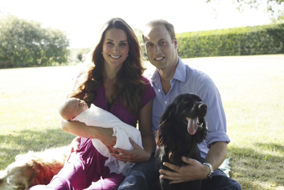 Britain's Prince William and his wife Catherine, Duchess of Cambridge, pose with their son Prince George in the garden of the Middleton family home in Bucklebury, southern England