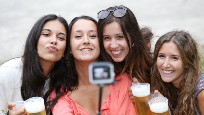 Feierbanane: Friedlich feiernde junge Spanierinnen posieren lächelnd für ein Selfie auf Münchens Feiermeile.
