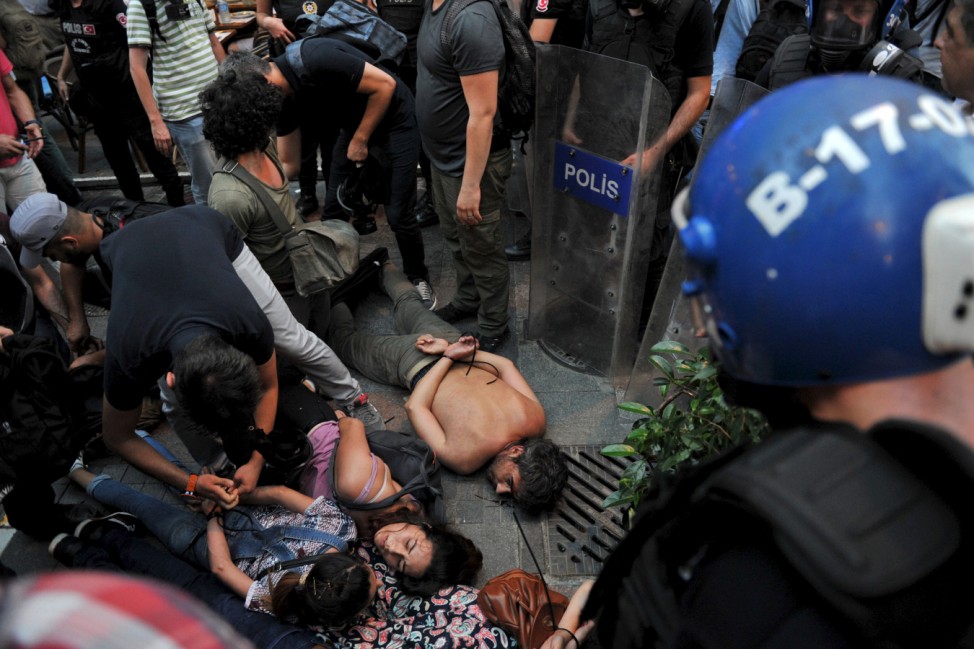 Plainclothes police officers detain demonstrators during protests against Monday's bomb attack in Suruc, in Istanbul, Turkey