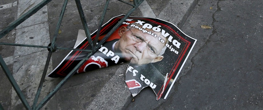A torn referendum campaign poster depicting German Finance Minister Schaeuble is seen on a street in Athens