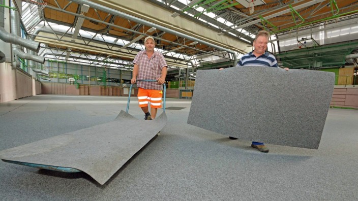 Puchheim: Vorbereitung auf Flüchtlinge: Arbeiter verlegen Teppichboden in der Dreifachturnhalle des Gymnasiums.