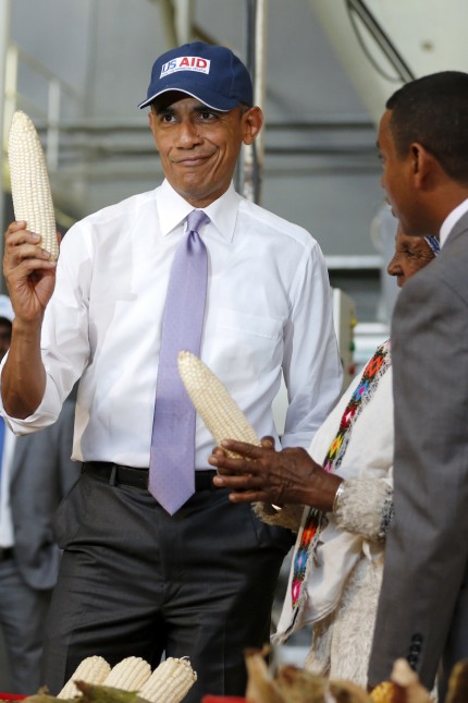 U.S. President Obama shows off a ear of corn grown by a farmer participating in the Feed the Future program as he tours the Faffa Food factory in Addis Ababa
