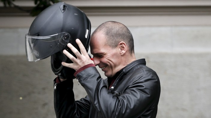 File photo of Greek Finance Minister Varoufakis wearing his helmet before leaving the Maximos Mansion on his motorbike after a meeting with PM Tsipras in Athens