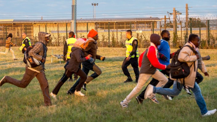 Flüchtlingskrise in Calais: Sie setzen auf den richtigen Moment: Flüchtlinge rennen in Richtung Eurotunnel.