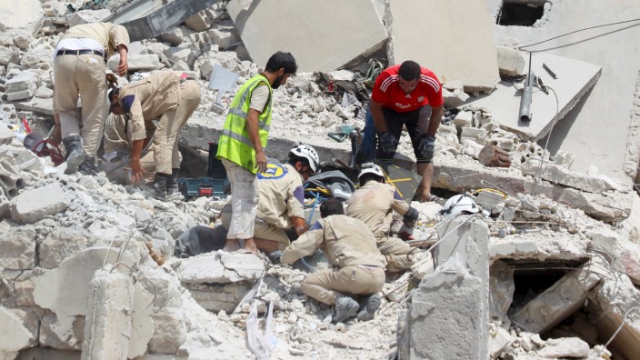 Civil defence members search for survivors under the rubble after a Syrian army fighter jet crashed into a busy marketplace in the rebel-held northwestern town of Ariha