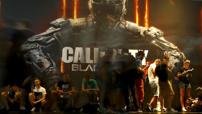 Visitors queue to play the video game 'Call Of Duty: Black Ops III' during the Gamescom fair in Cologne