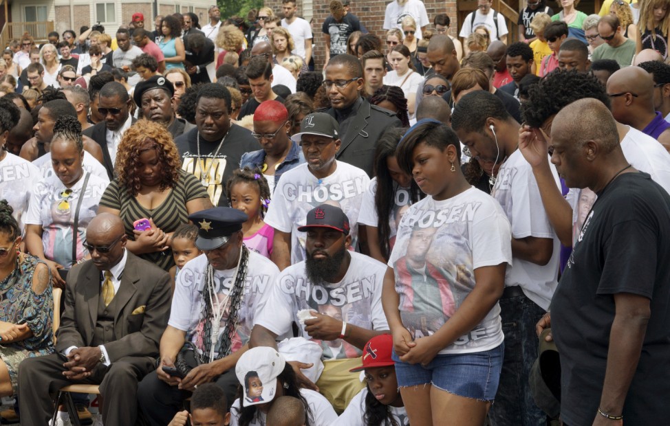 Michael Brown Sr., at the spot where his son was killed, listens with other family members at an event to mark the one-year anniversary of the killing of his son Michael Brown in Ferguson