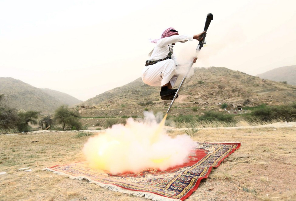 Man fires a weapon as he dances during a traditional excursion near the western Saudi city of Taif