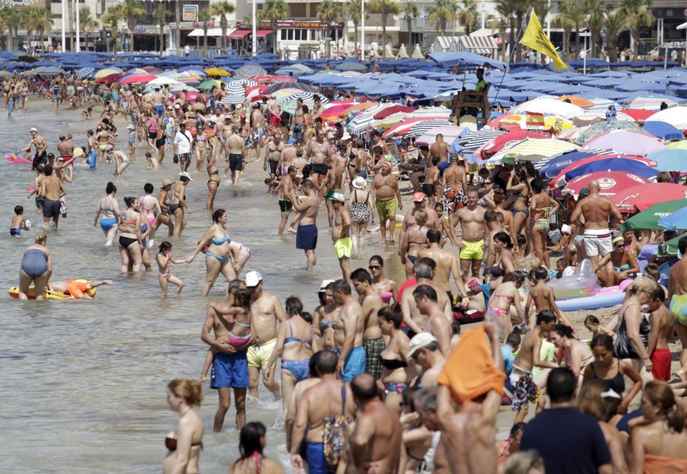 People relax at the beach during a hot summer day in Benidorm