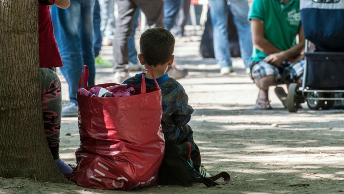Ein Kind sitzt in Berlin vor dem Landesamt für Gesundheit und Soziales.