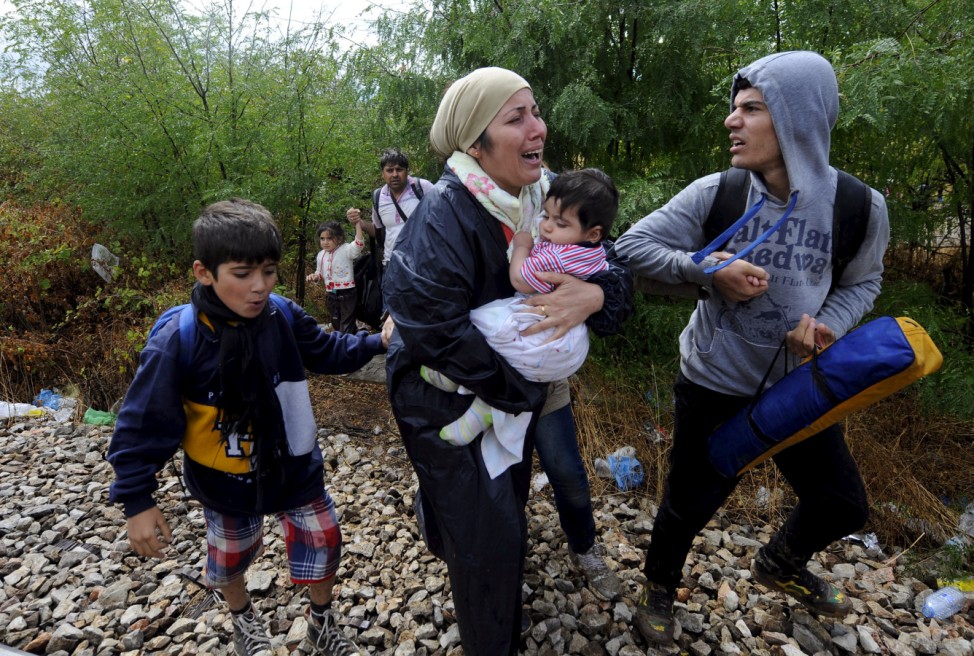 Migrants cry and walk towards Gevgelija in Macedonia after crossing Greece's border