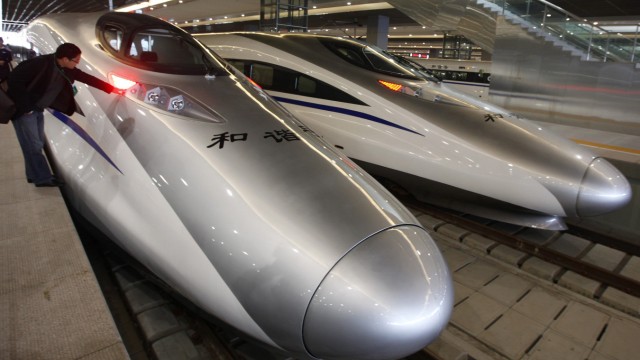 A man looks at the bullet trains serving the new high-speed railway linking Shanghai and Hangzhou in Shanghai