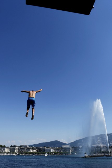 A teenager jumps off the diving platform of Bains des Paquis in Geneva