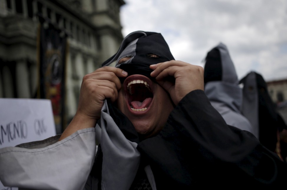 Hooded student of the San Carlos University of Guatemala shouts slogans during a demonstration against the government of the Guatemalan President Perez Molina, in Guatemala City