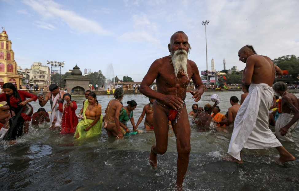 A Sadhu or a Hindu holy man leaves after taking a dip  in the Godavari river during the first 'Shahi Snan' (grand bath) at 'Kumbh Mela', or Pitcher Festival in Nashik