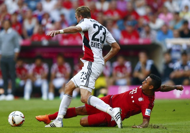 Munich's Thiago tackles Kramer of Leverkusen during their German first division Bundesliga soccer match in Munich