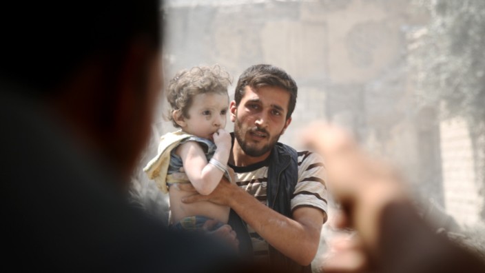 Flüchtlinge: Ein syrischer Vater mit seinem Kind während einer Ausschreitung in Damaskus.