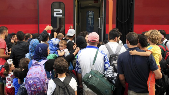 Travellers try to board a train to Austria at the railway station in Budapest