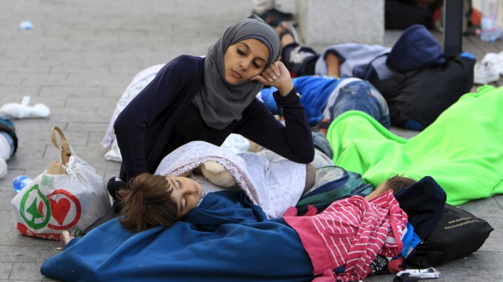 Migrants rest outside the main Eastern Railway station in Budapest